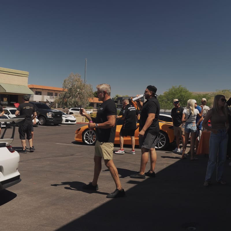Drivers and guests gathered in the parking lot outside the launch venue before rolling out.