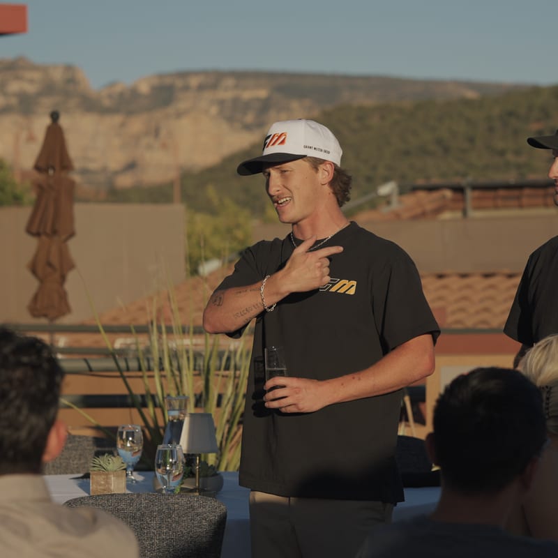 A rally guest standing to address the tables at the Sedona rooftop dinner.